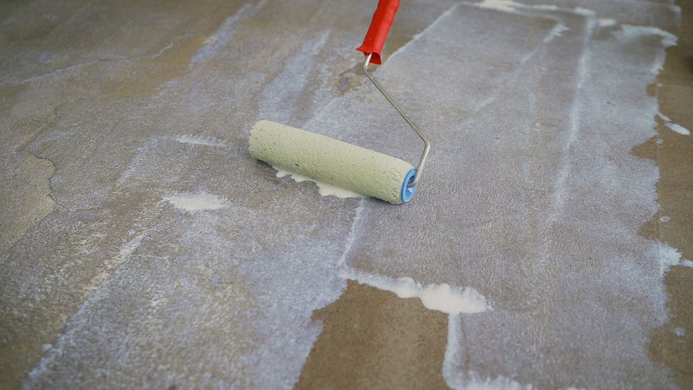 applying pva on the concrete floor using paint roller