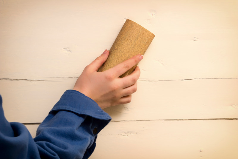 hand sanding a wall using sandpaper