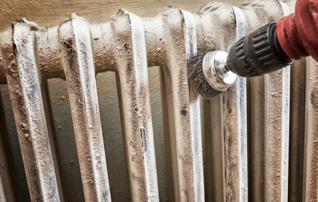 sanding a radiator with wire brush drill attachment