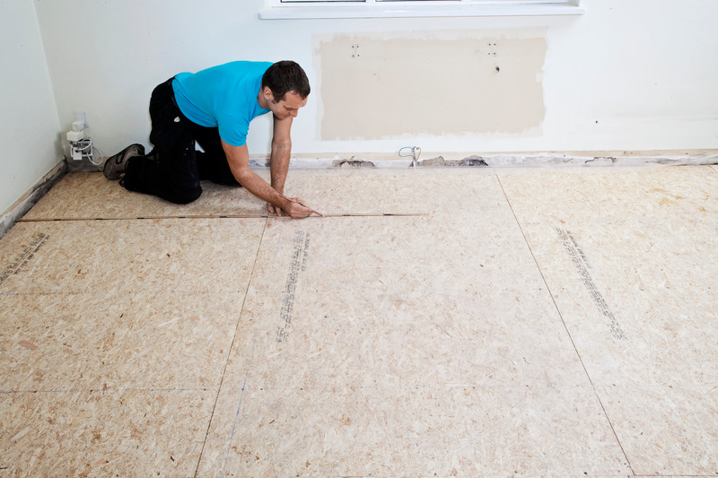 man measuring and laying chipboard