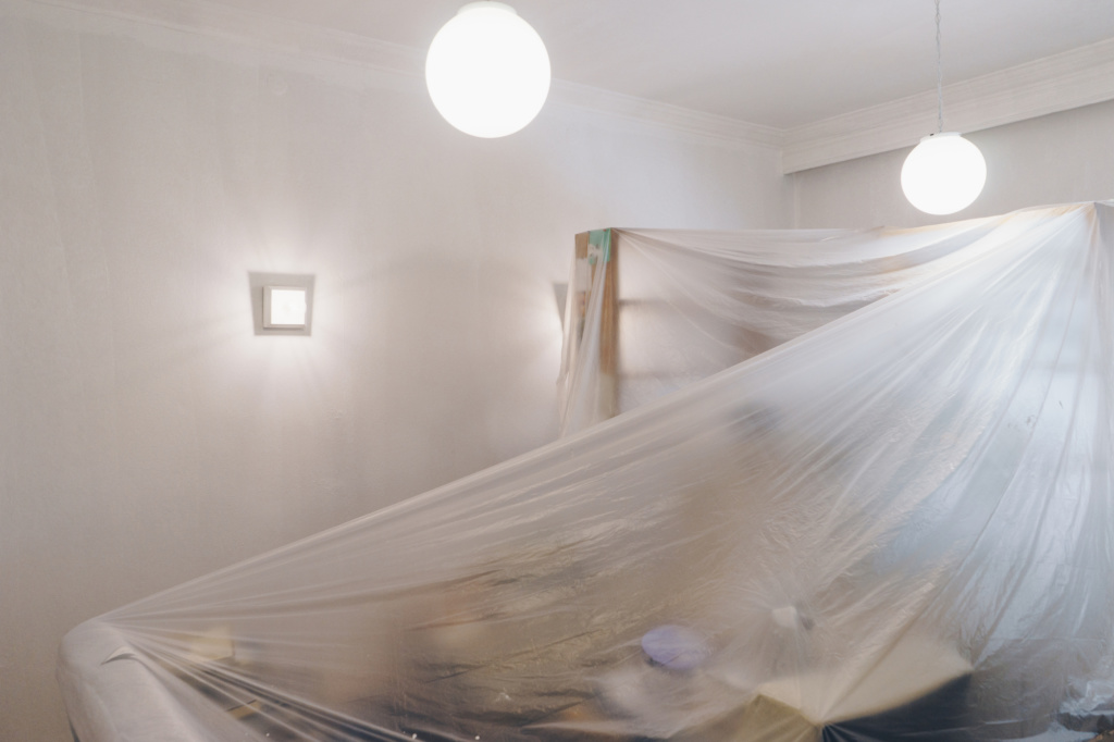 living room furniture covered with protective plastic sheeting